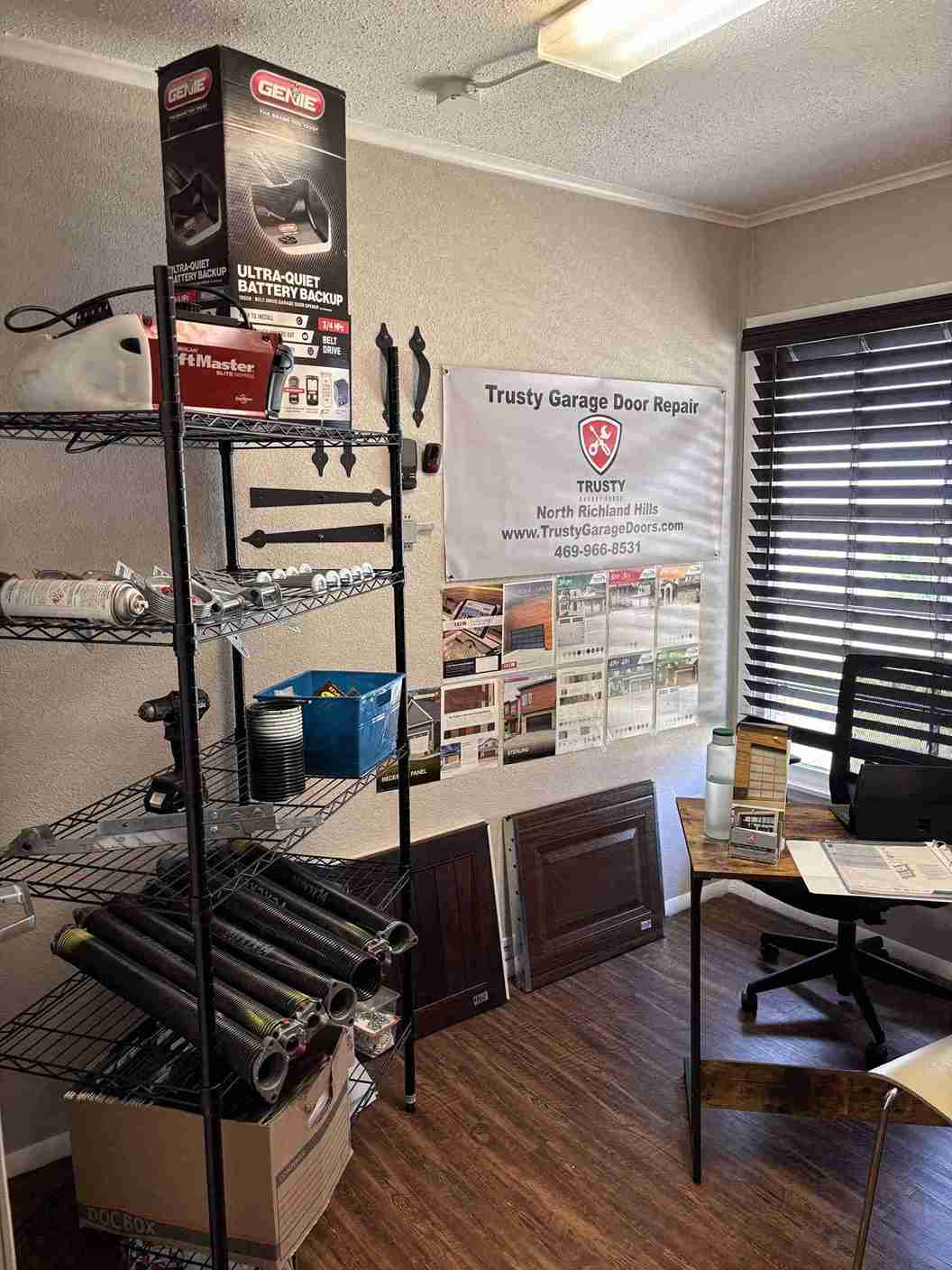 Trusty Garage Door Repair office with parts shelves, sample panels, and a desk.